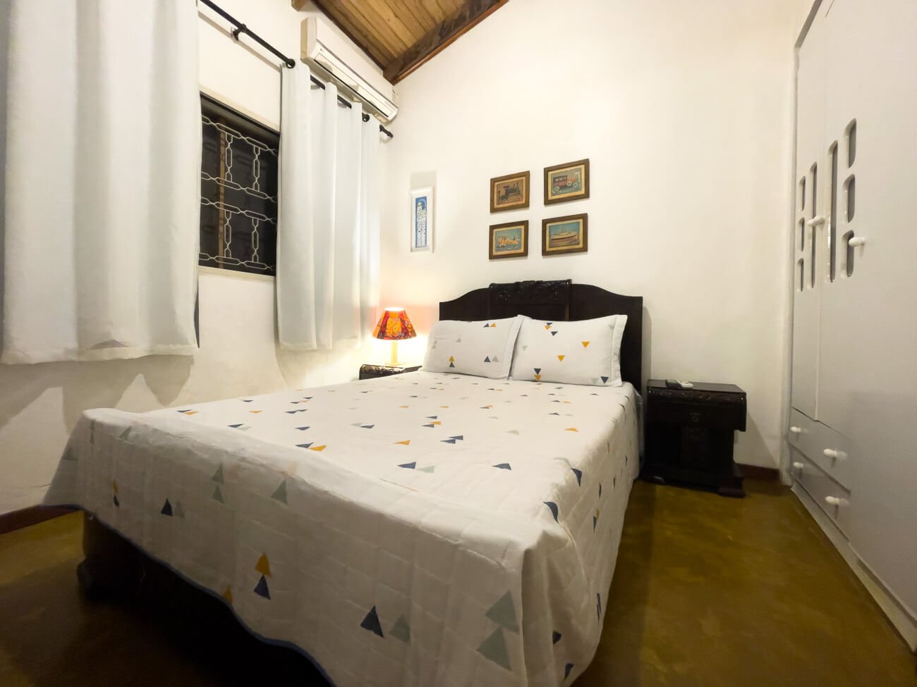 Cama de casal em quarto de decoração rústica.