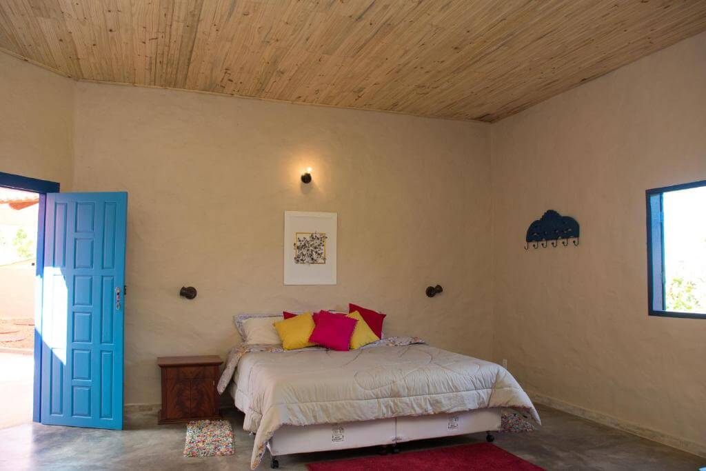 Quarto espaçoso com cama de casal e decoração rústica em pousada em Pirenópolis