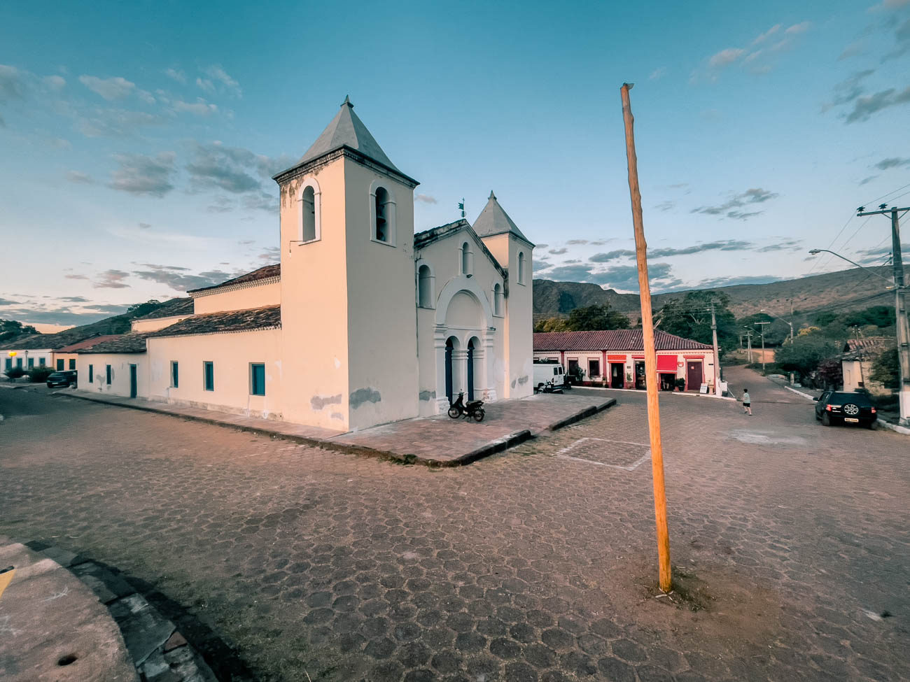 Fachada da Igreja Matriz Nossa Senhora da Natividade com duas torres laterais em rua de pedra
