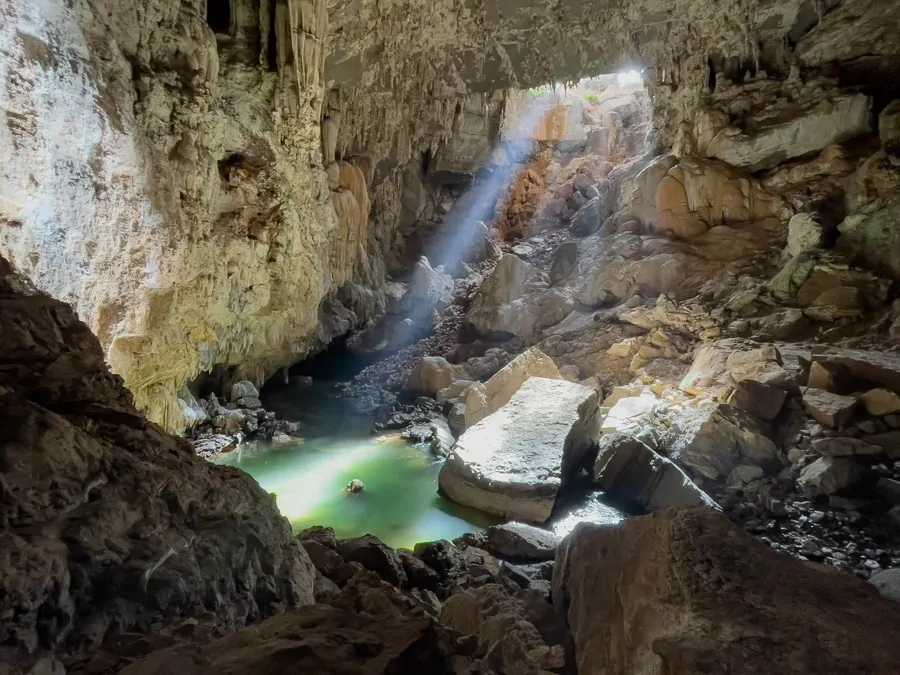 Lago de águas cristalinas localizado dentro da caverna Terra Ronca II recebendo luz do sol em uma fenda do alto