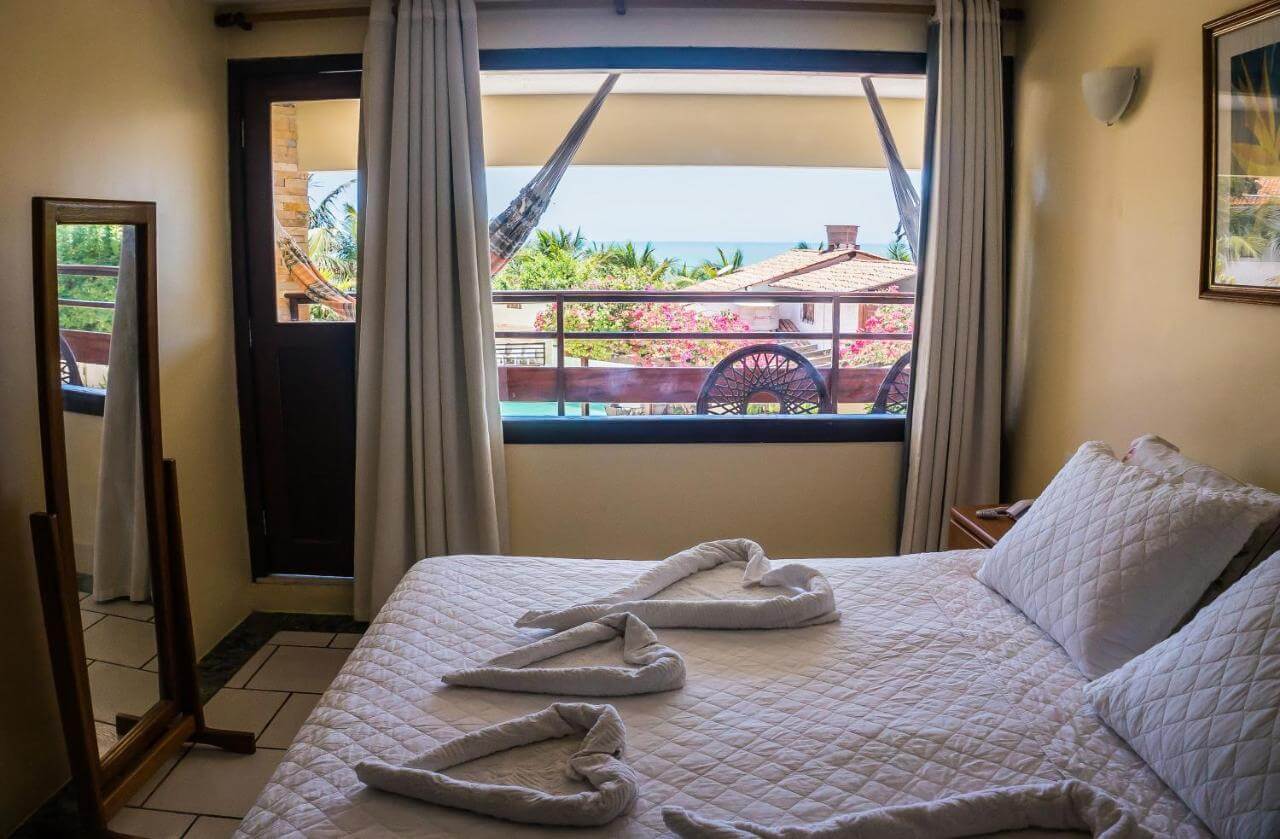 Quarto de casal com janela com vista para outras construções