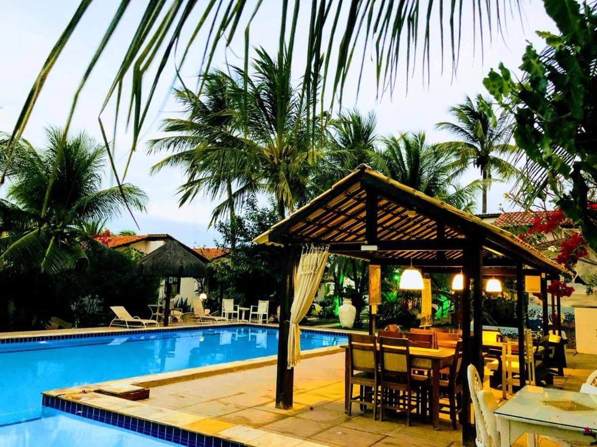 Piscina ao ar livre com poltronas em área coberta