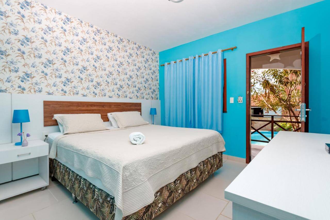 Quarto de casal, com parede azul e outra com papel de parede