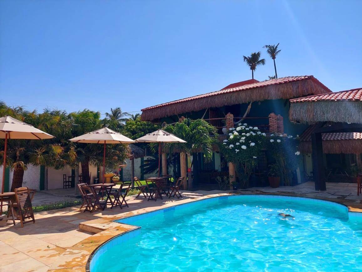 Piscina ao ar livre com área coberta com mesas e cadeiras