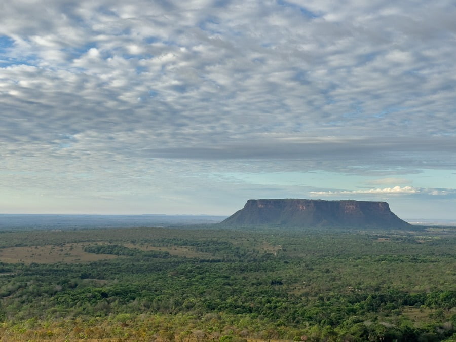 Grande área da Chapada das Mesas repleta de vegetação e ao fundo formação rochosa do Morro do Chapéu