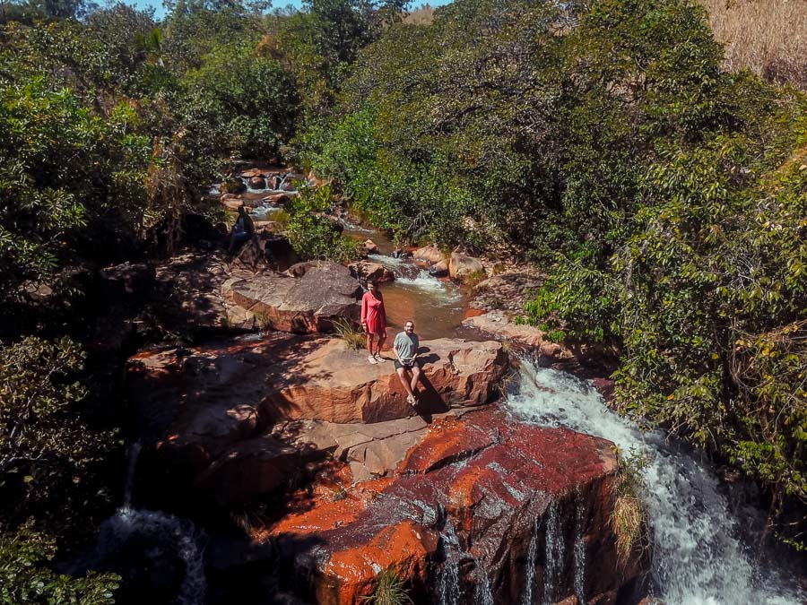 Um homem e uma mulher no topo da queda d'água da Cachoeira do Bartolomeu