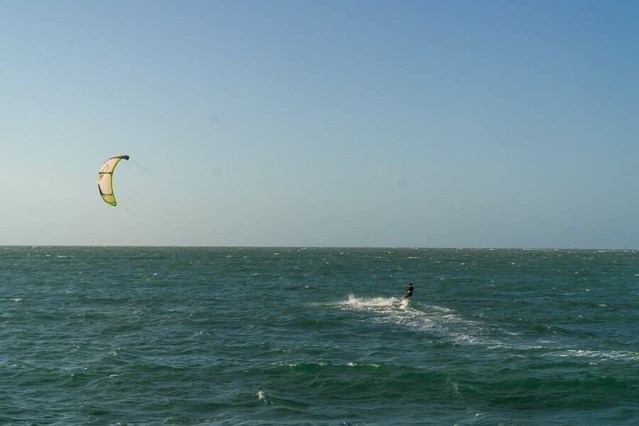 Mar da Praia de Barra Grande do Piauí em tom azulado com um homem praticando kitesurf