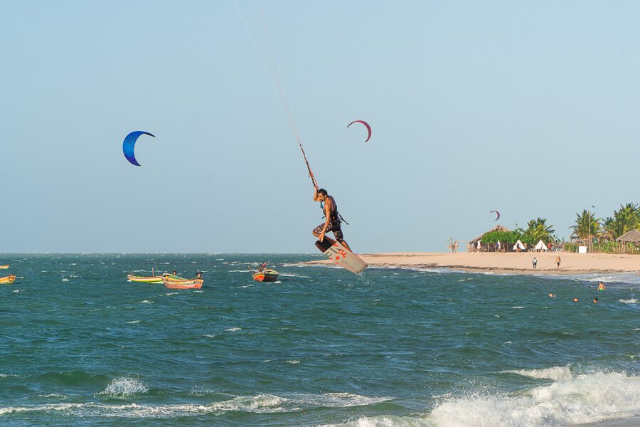 Homem saltando sobre o mar de Barra Grande do Piauí praticando kitesurf