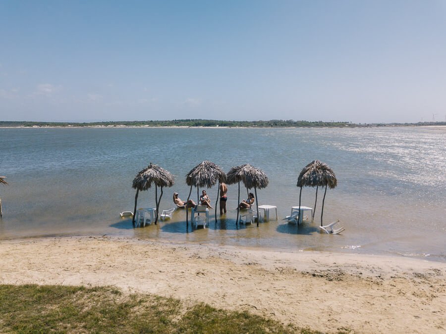 Lago das Cangalhas em Camocim com águas cristalinas e guarda-sóis em palha