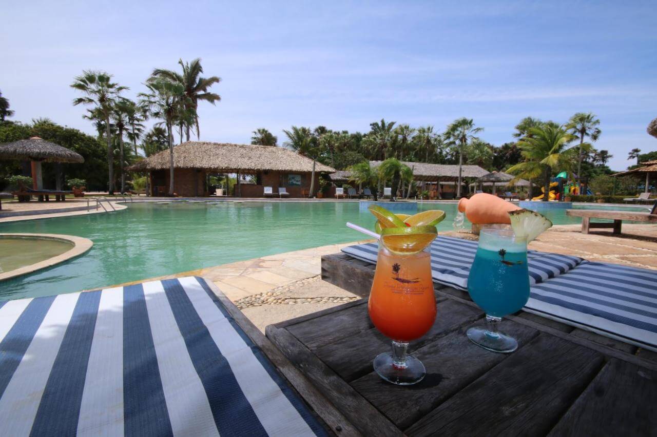 Coquetéis em mesa de frente para piscina ao ar livre em resort em Barreirinhas