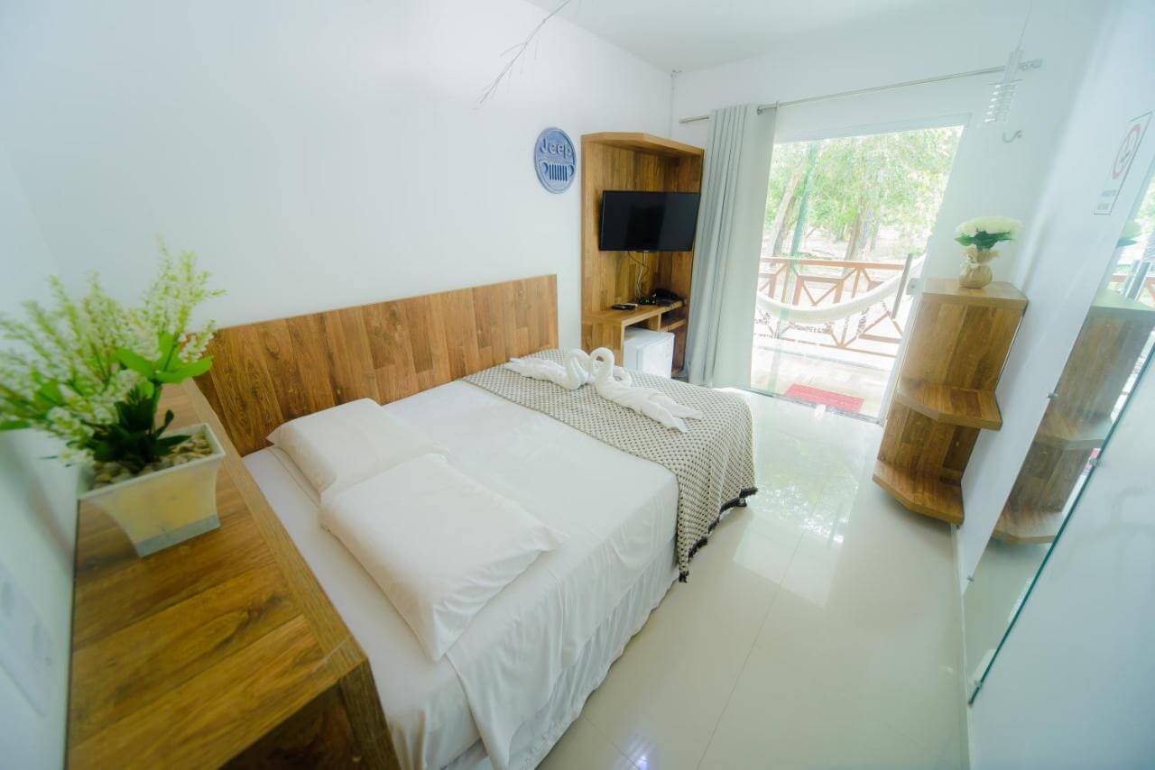 Cama de casal em quarto com sacada em pousada em Barreirinhas