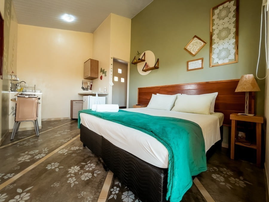 Quarto com móveis de madeira e cama de casal em chácara na Chapada dos Veadeiros