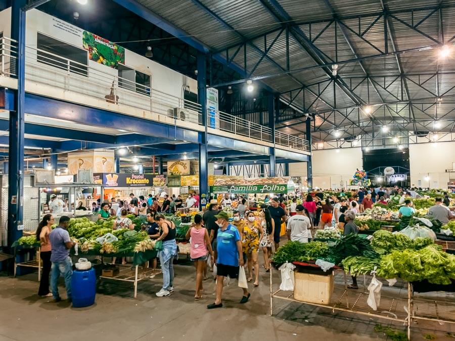 Feira 304 Sul com verduras expostas e pessoas caminhando