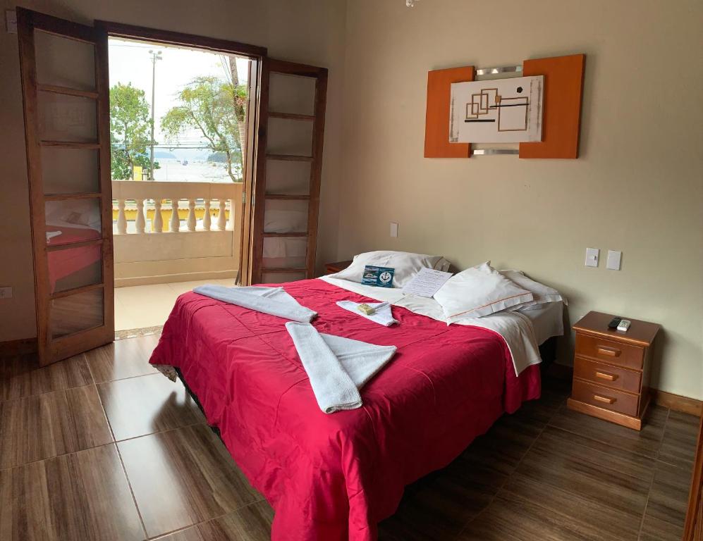 Cama de casal em quarto de pousada em Ubatuba