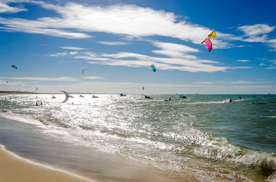 Mar cristalino da Praia de Cumbuco com praticantes de kitesurfe