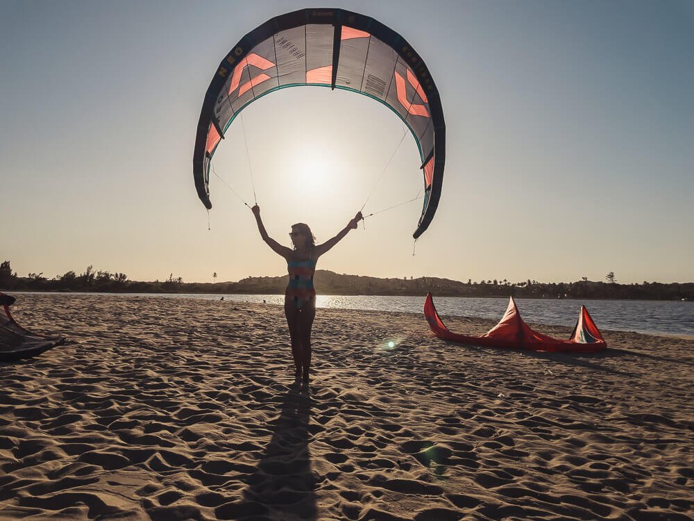 Por do sol com a Dri segurando um kite da marca Duotone