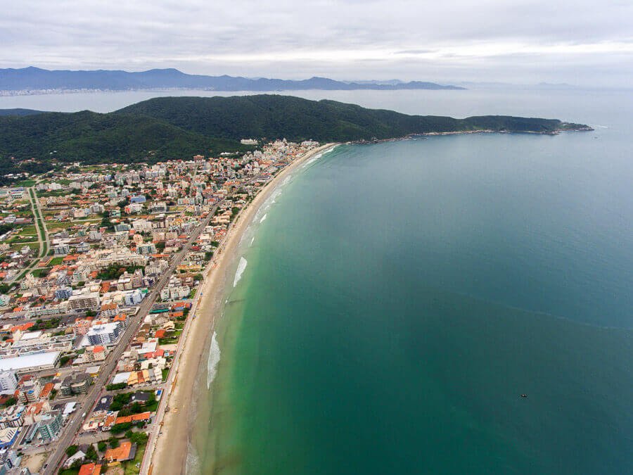 Vista aérea e panorâmica da Praia de Bombas com a orla repleta de construções