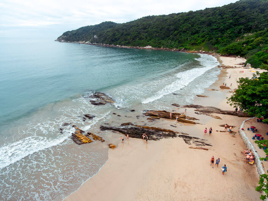 Praia Retiro dos Padres com algumas pedras na areia e cercada por montanha