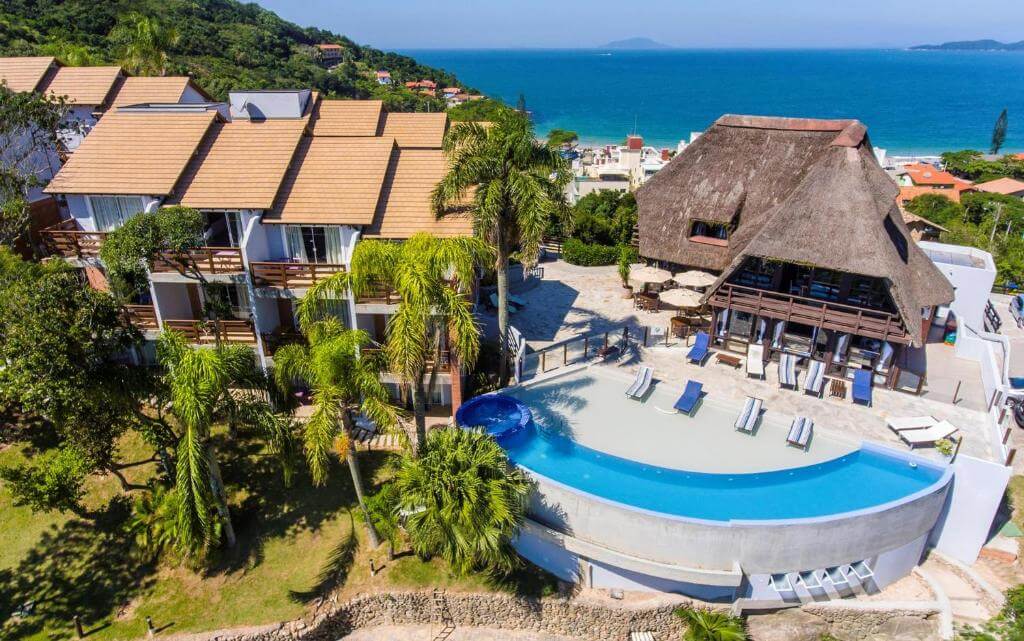 Vista aérea de pousada com piscina ao ar livre e estrutura rústica
