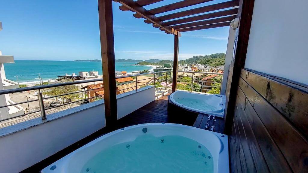 Duas jacuzzis em sacada de pousada com vista para o mar