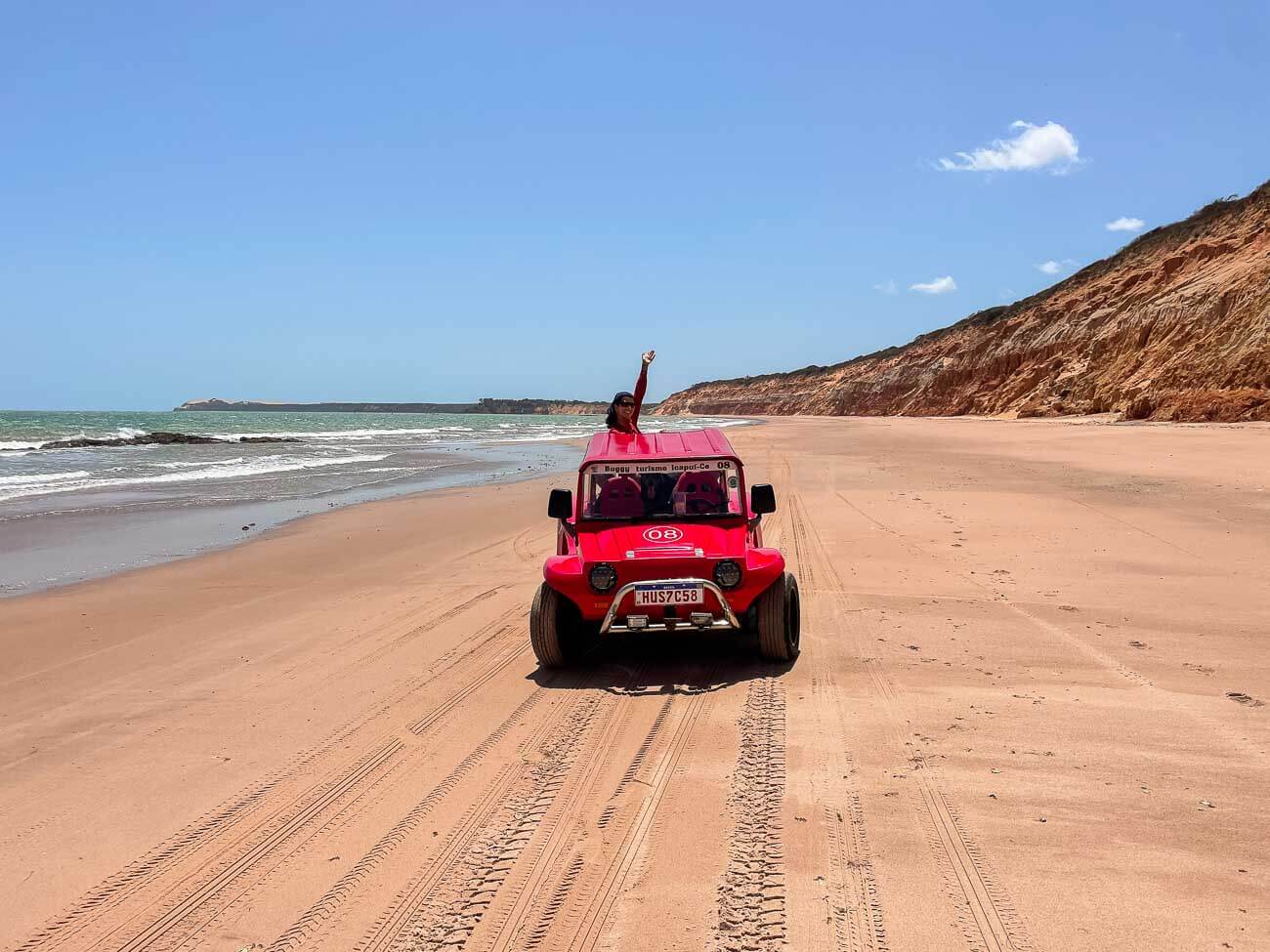 Mulher em buggy passando por praia em Canoa Quebrada