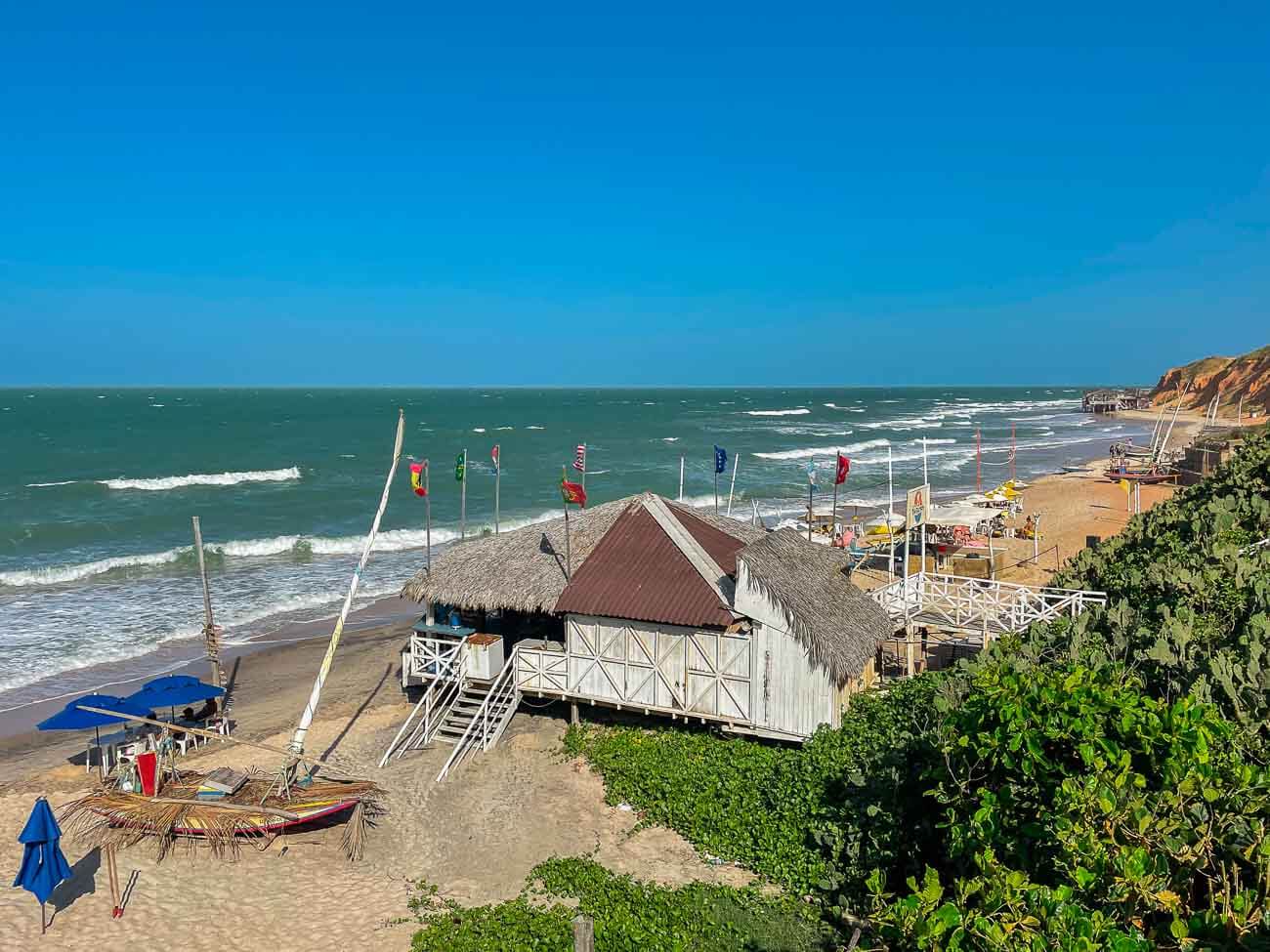 Vista de uma parte da Praia de Canoa Quebrada com barracas e jangadas na areia