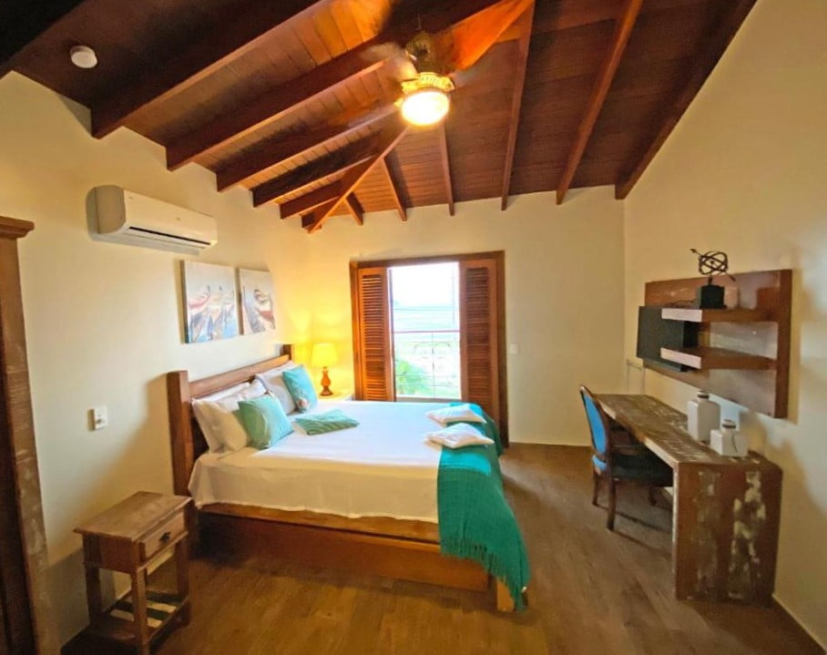 Quarto de casal com móveis rústicos e bem iluminado