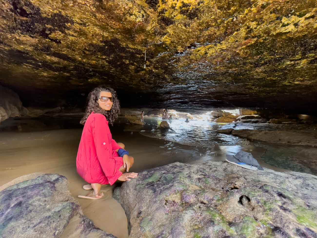 Mulher de vermelho agachada na Pedra Oca