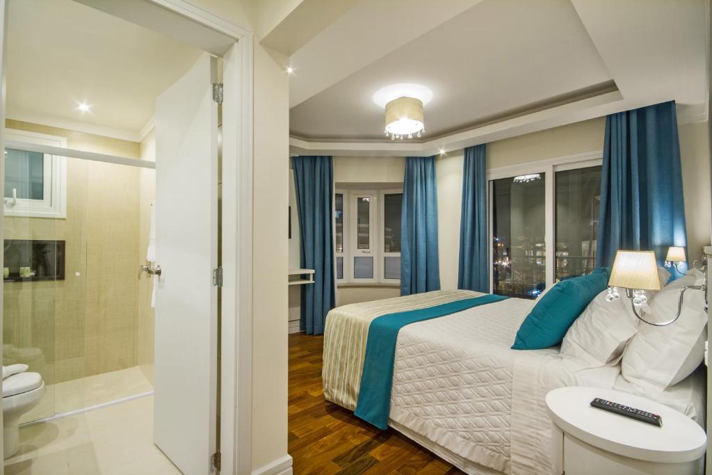 Quarto de casal com decoração em tons de branco e azul e móveis modernos