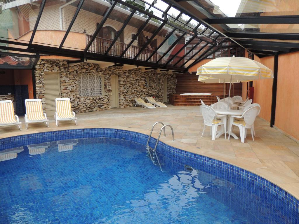 Piscina coberta e ao fundo deck de madeira com banheira