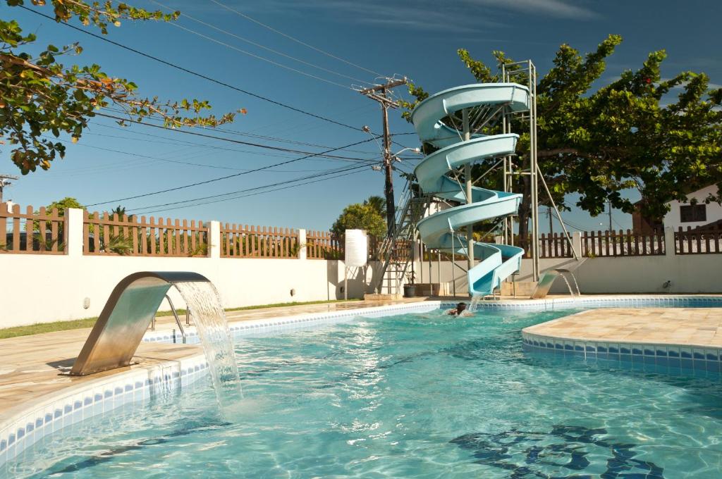 Piscina ao ar livre com toboágua e cascata em pousada
