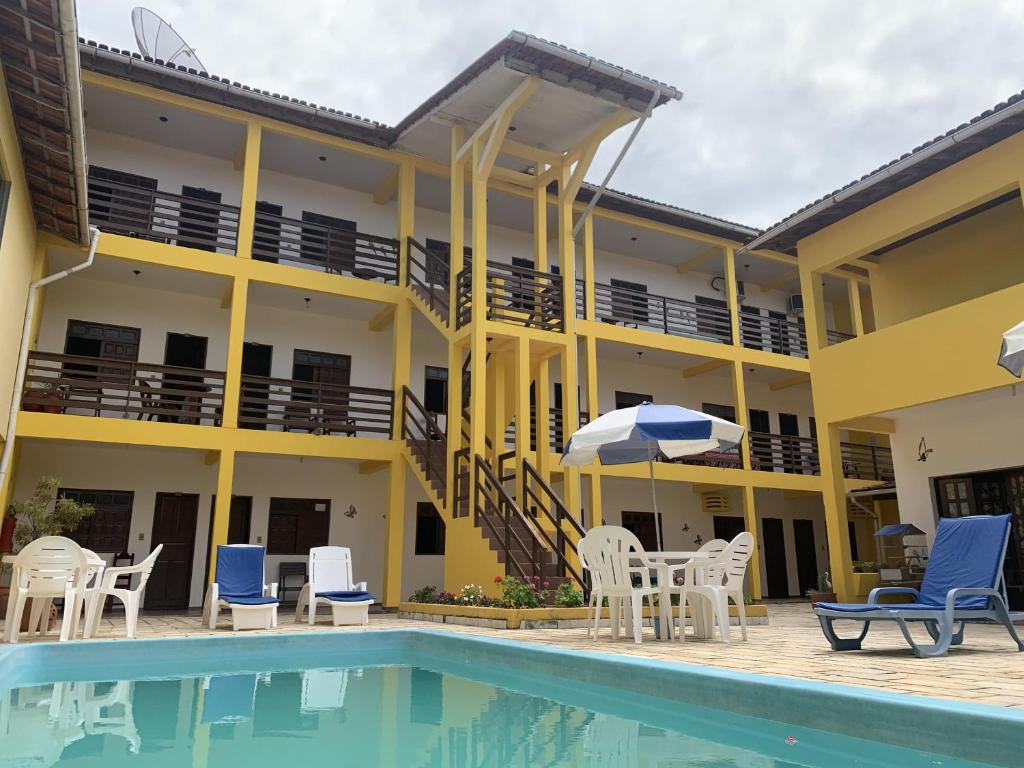 Piscina ao ar livre e ao fundo pousada de três andares em Prado Bahia