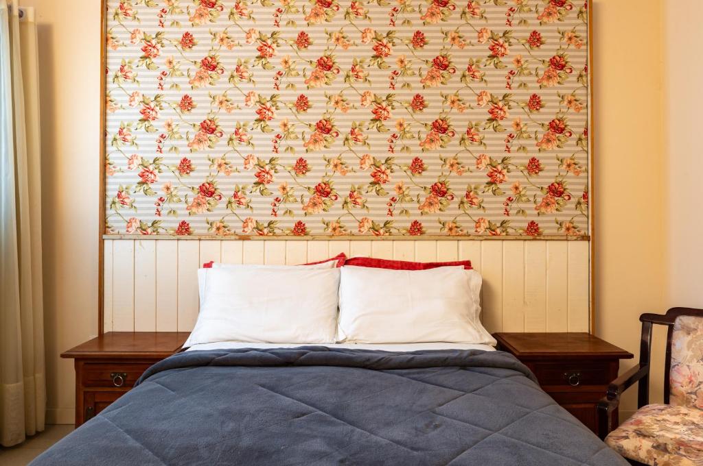 Quarto de casal em pousada com papel de parede florido