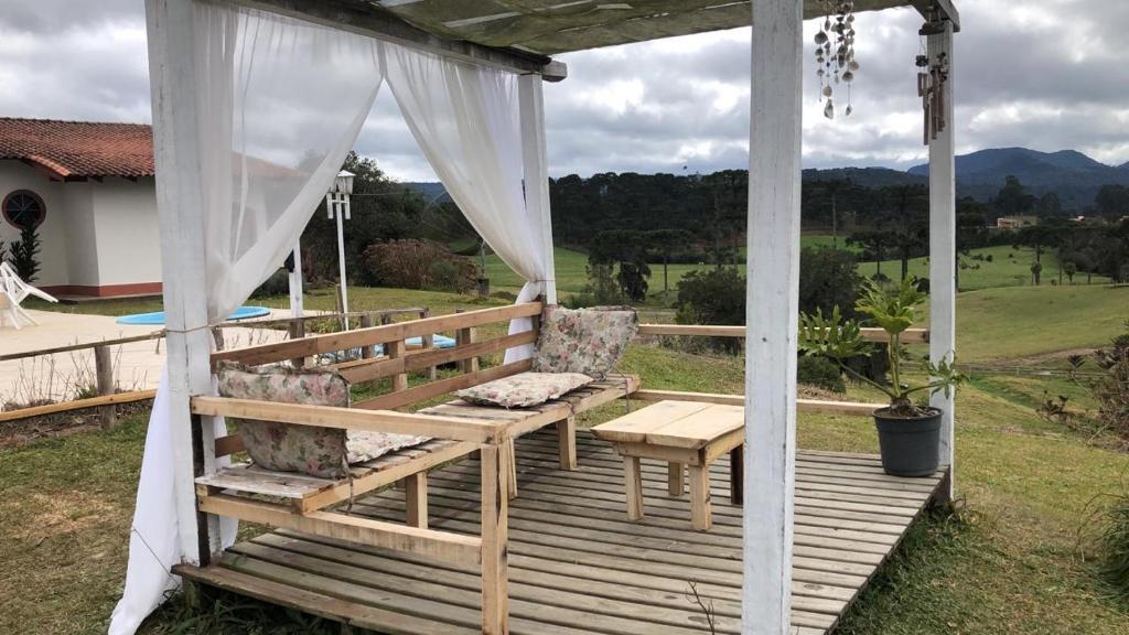 Área coberta com sofás de madeira rústico em pousada em Urubici