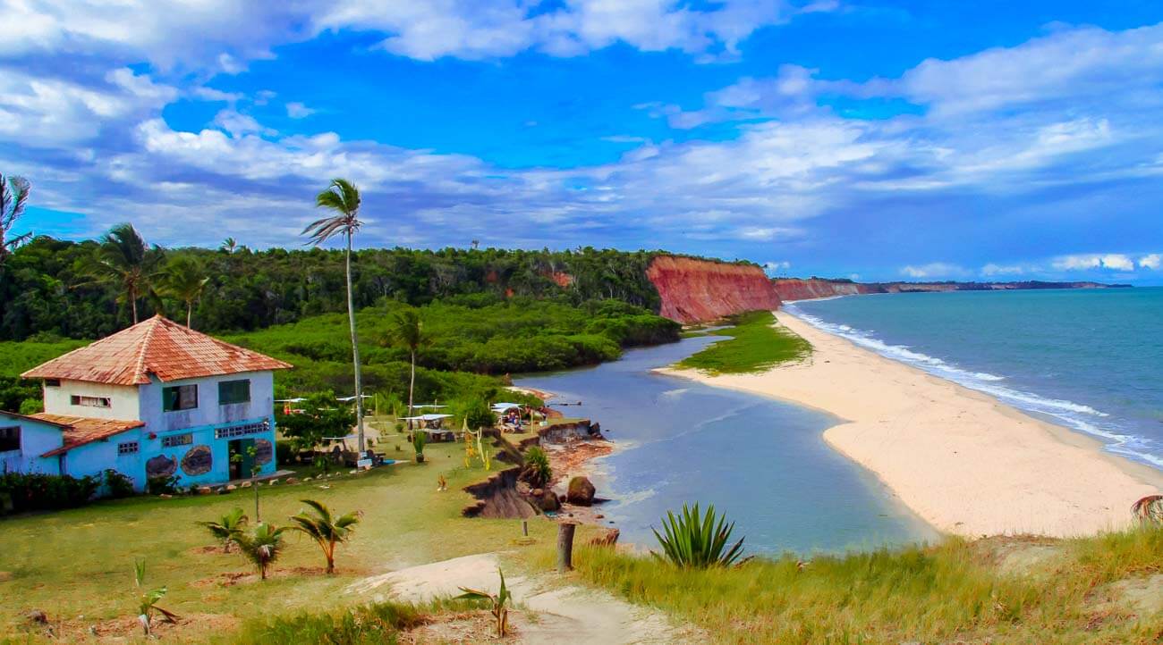 Vista de cima da Praia Japara Grande com bastante vegetação e falésias