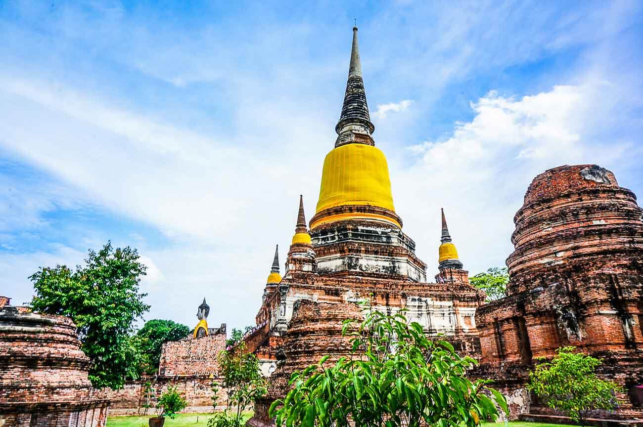 Templo histórico com stupas de tijolos e cúpulas douradas na cidade de Ayutthaya, perto de Bangkok.