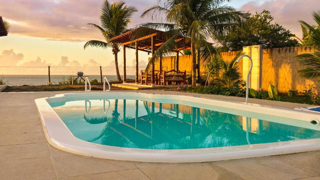 Piscina ao ar livre durante o pôr do sol em pousada em Cumuruxatiba