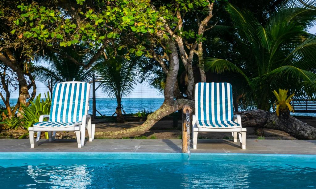 Piscina ao ar livre com duas espreguiçadeiras na borda.