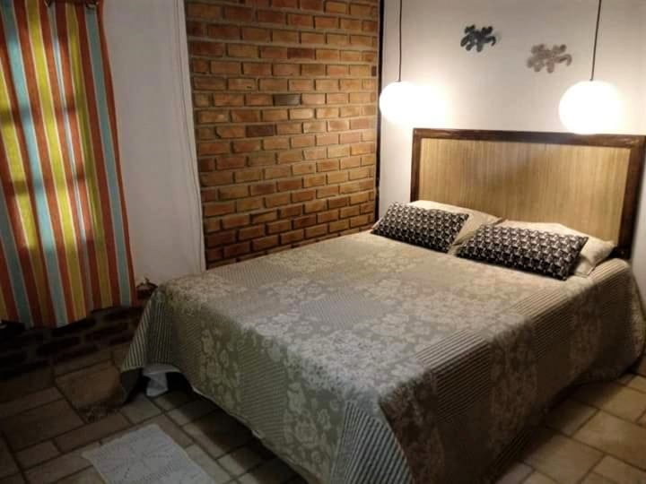 Quarto de casal com detalhes rústicos em pousada em Cumuruxatiba