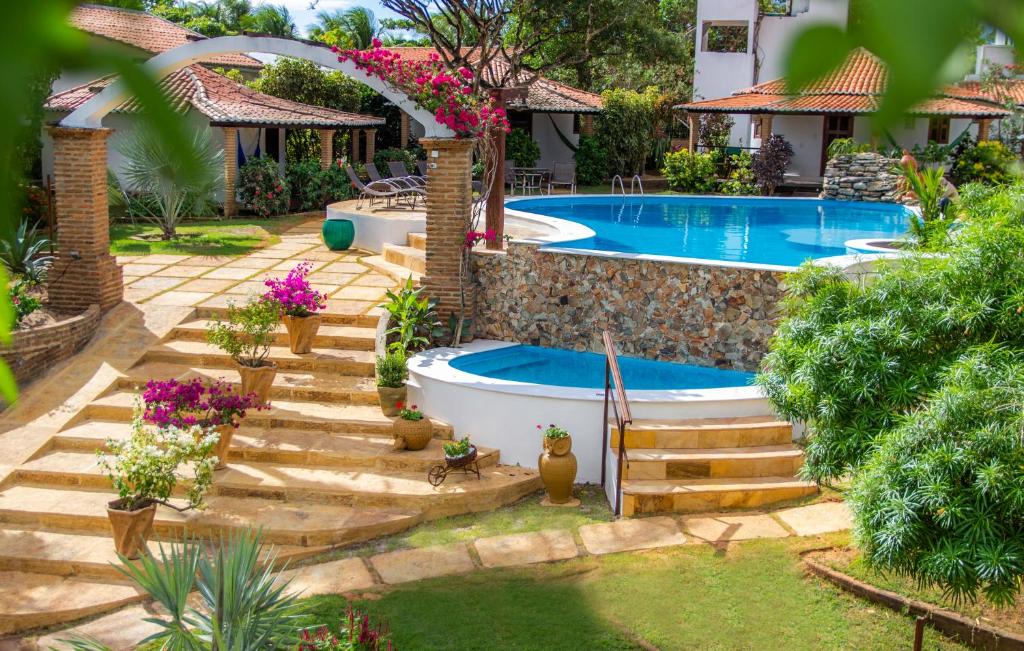 Piscinas ao ar livre em área cercada por jardim em pousada em Jericoacoara