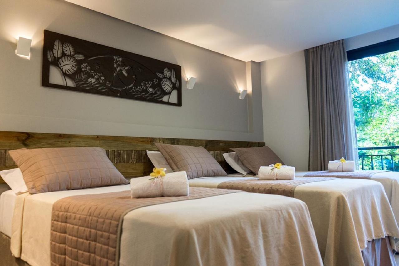 Quarto com cama de casal e uma de solteiro com decoração moderna em pousada em Morro de São Paulo.