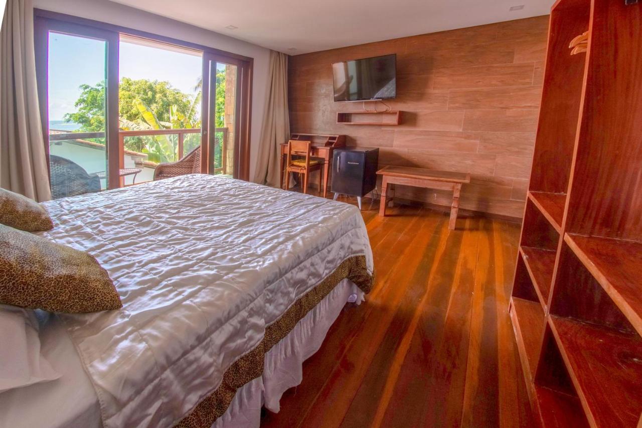 Quarto de casal com decoração moderna e sacada em pousada em Morro de São Paulo.