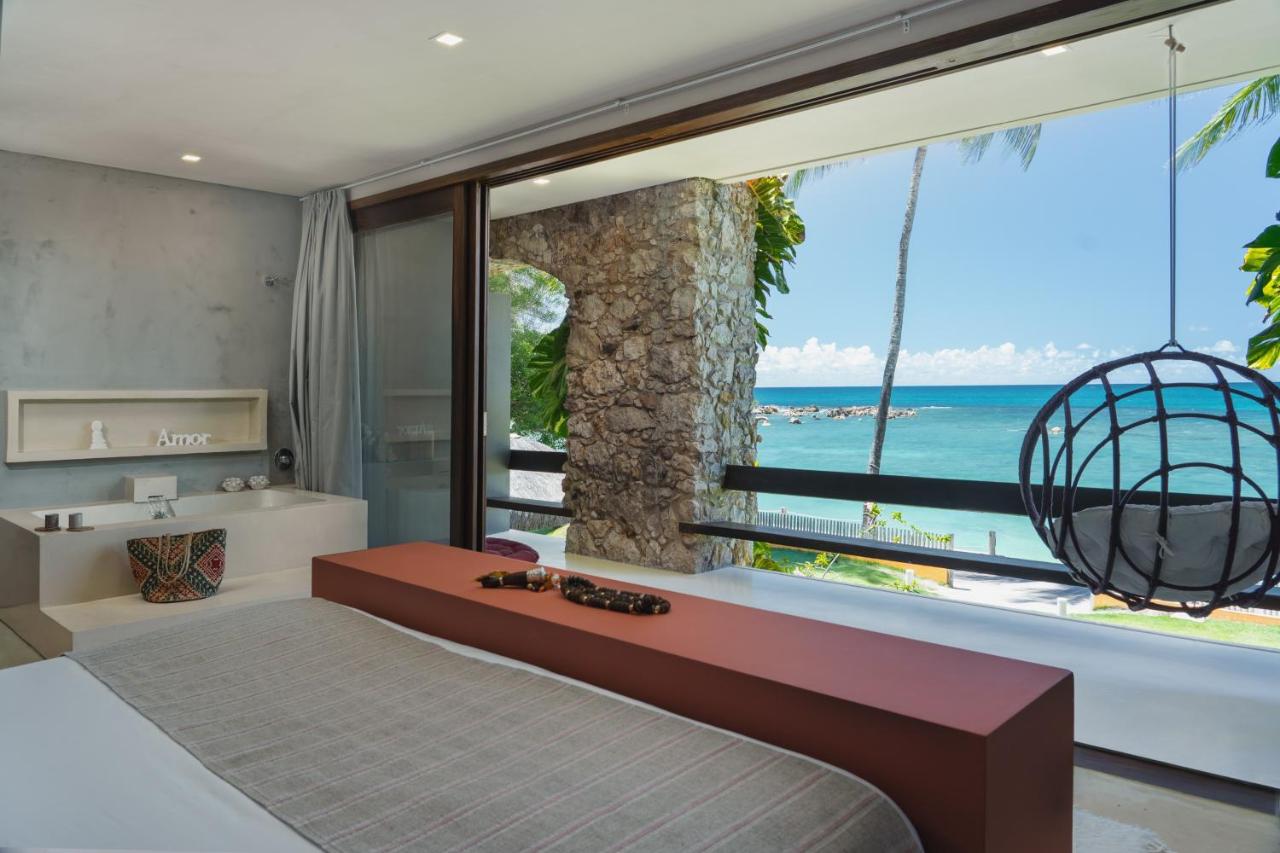 Quarto de casal elegante com sacada com vista para o mar da Terceira Praia em Morro de São Paulo.