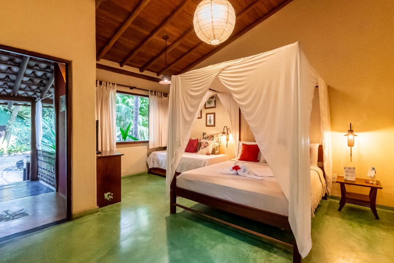 Quarto rústico com cama de casal e solteiro, bem iluminado em pousada em Trancoso.