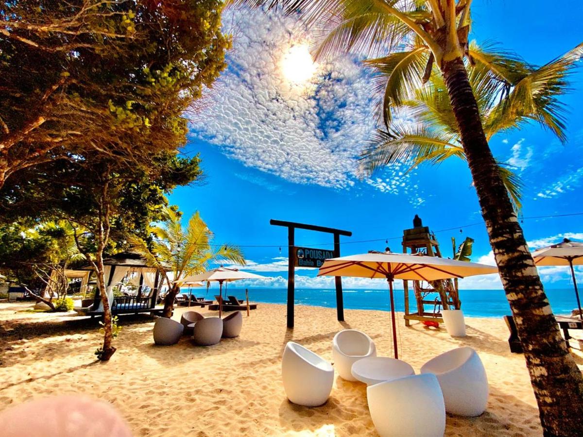 Área privativa de pousada em Trancoso em praia com puffs e guarda-sóis.