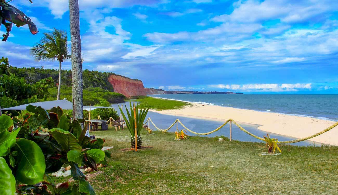 Vista de cima da Praia Japara Grande com bastante vegetação e falésias ao fundo