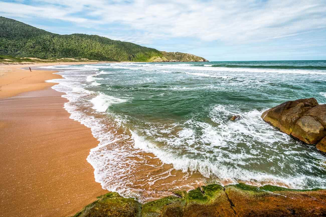 Mar de águas claras e faixa de areia vazia na Praia Lagoinha do Leste