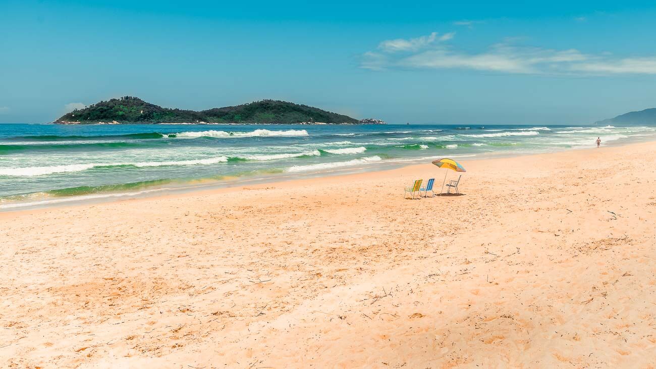 Faixa de areia larga e extensa da Praia do Campeche em um dia vazio