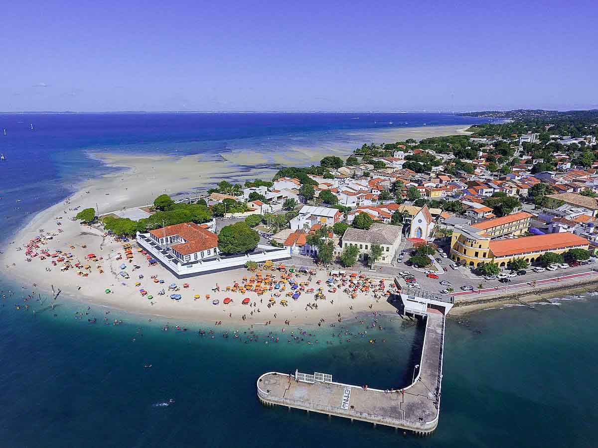 Vista aérea da Ilha de Itaperica com faixa de areia clara e repleta de banhistas