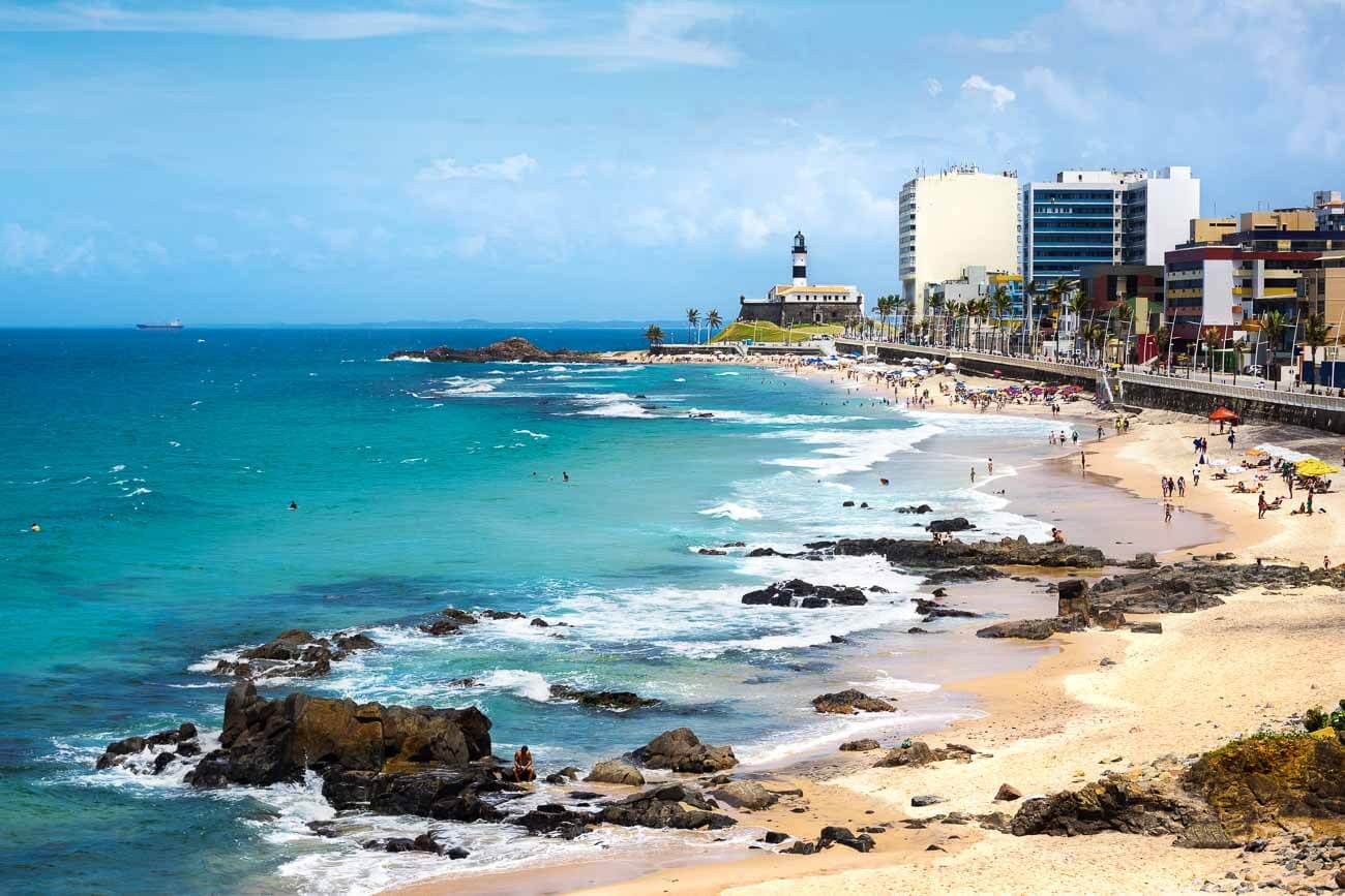 Águas claras da Praia do Farol da Barra e ao fundo o Farol.